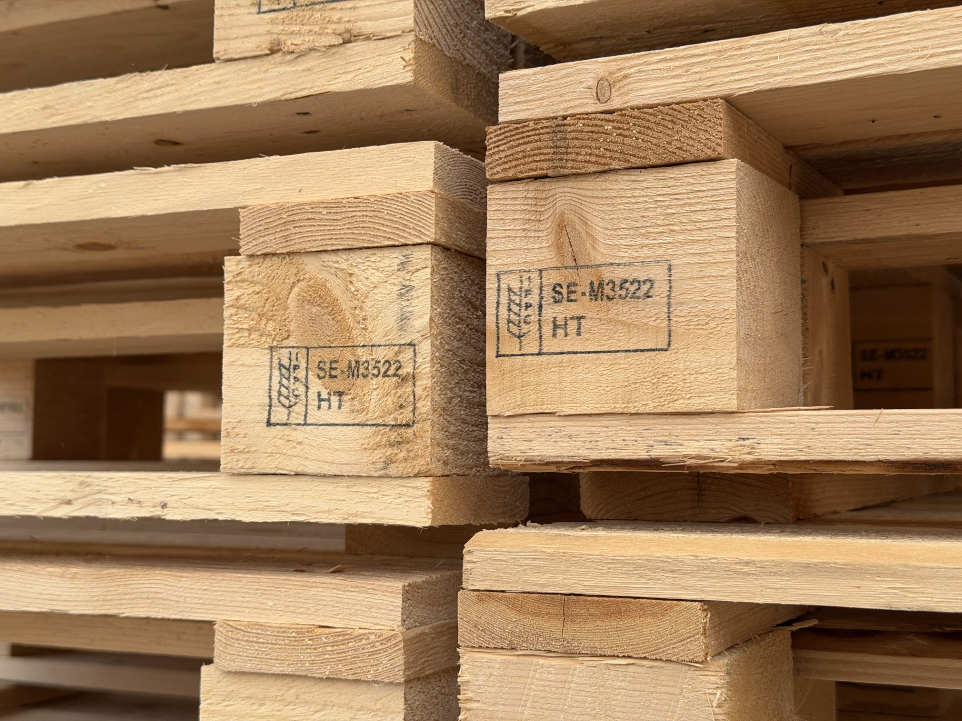 Close-up of wooden pallets with the IPPC symbol, operator number and HT treatment code on the blocks.
