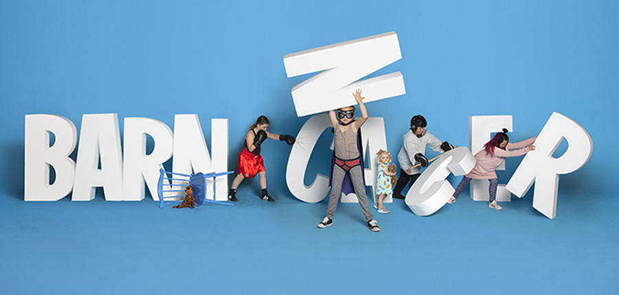 Children posing with large 3D letters for Barncancerfonden charity sponsorship campaign on a blue background.