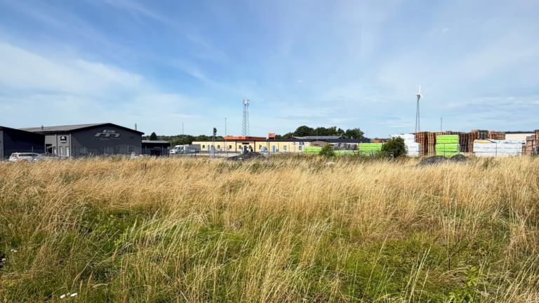The grass-covered plot at Kontoristgatan 2, next to GLF’s existing pallet and timber storage area in Genarp.