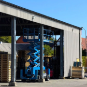 Blaue Scherenarbeitsbühne am Palettenlager von GLF in Genarp während der Montage des neuen Vogelschutzes.