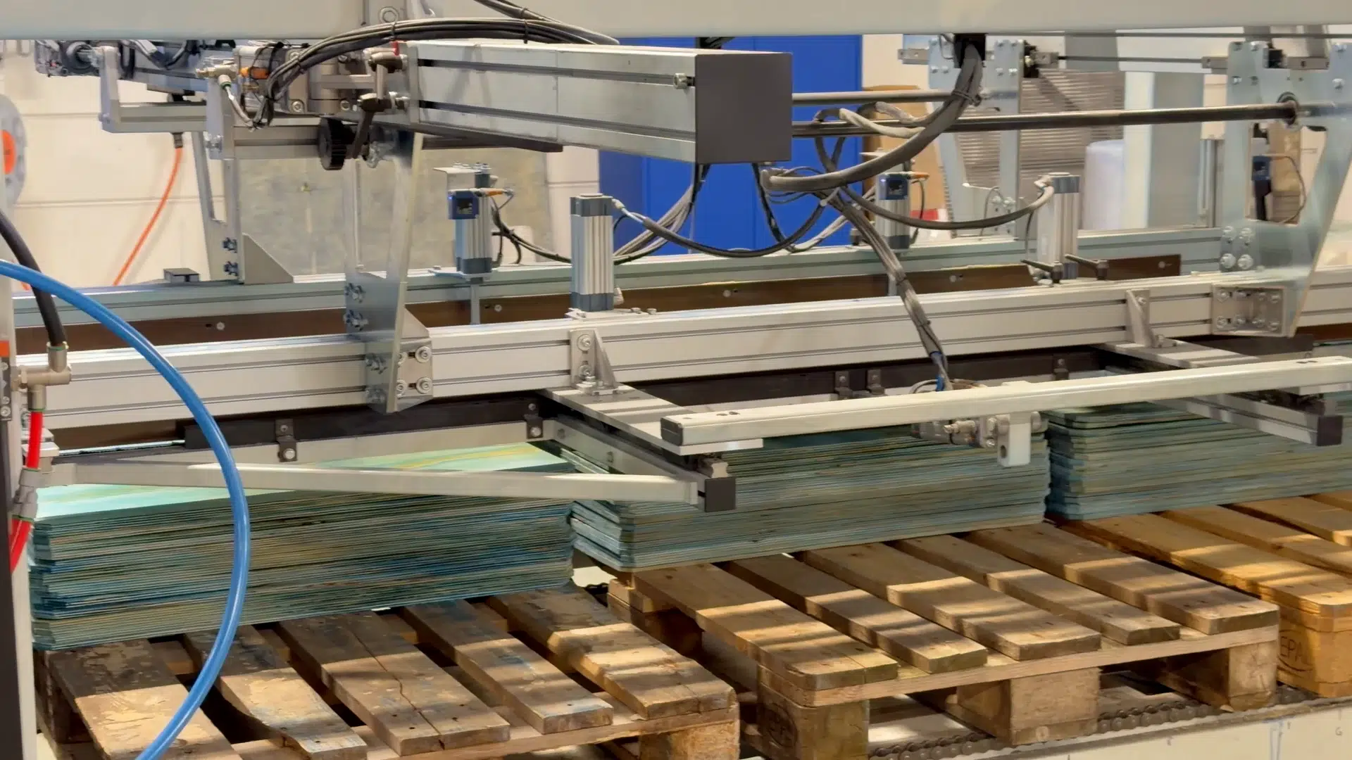 Painted blue-green sheets stacked beneath the handling equipment.
