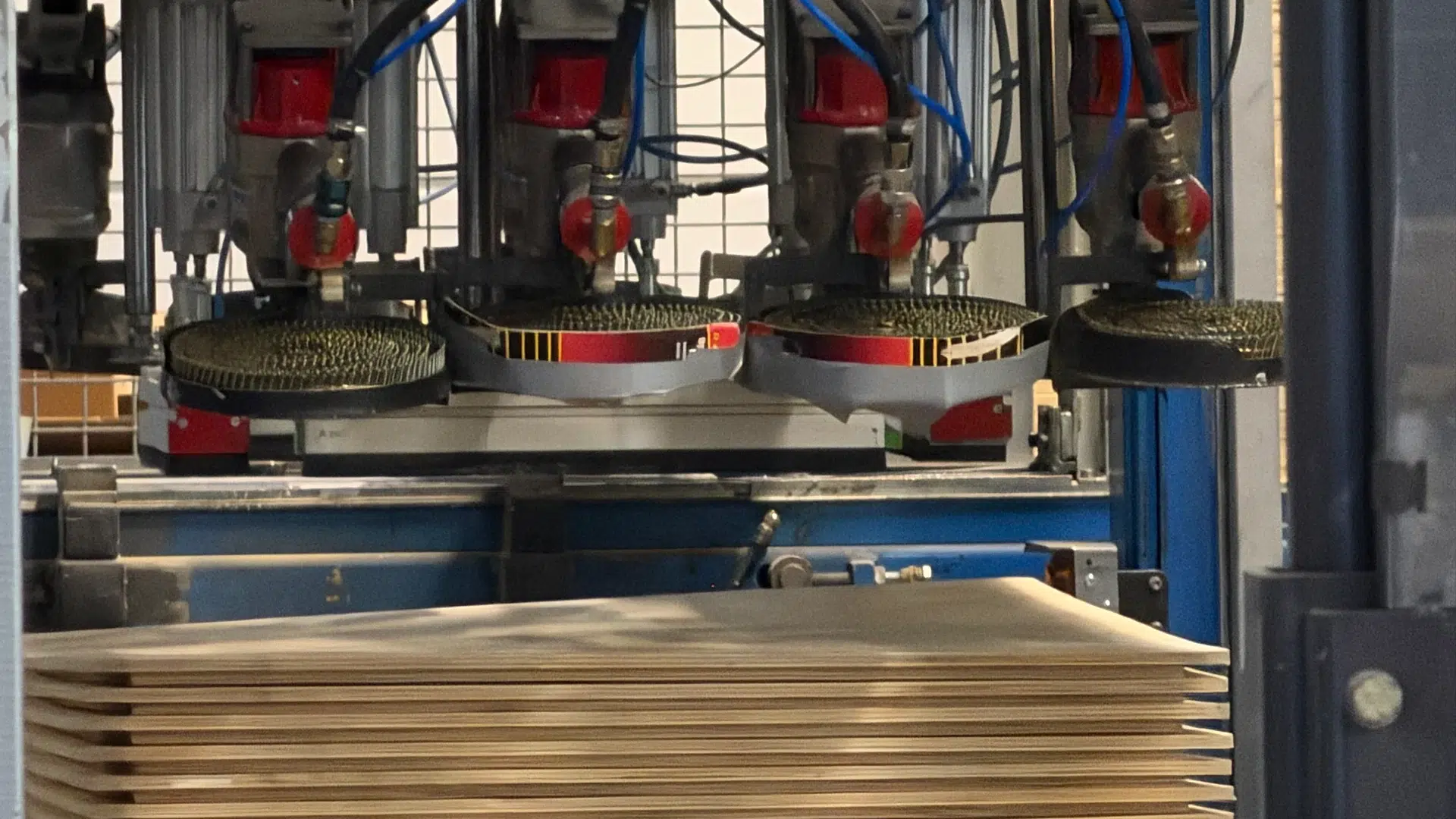 Nailing tools with coil magazines above plywood lids with wooden battens.