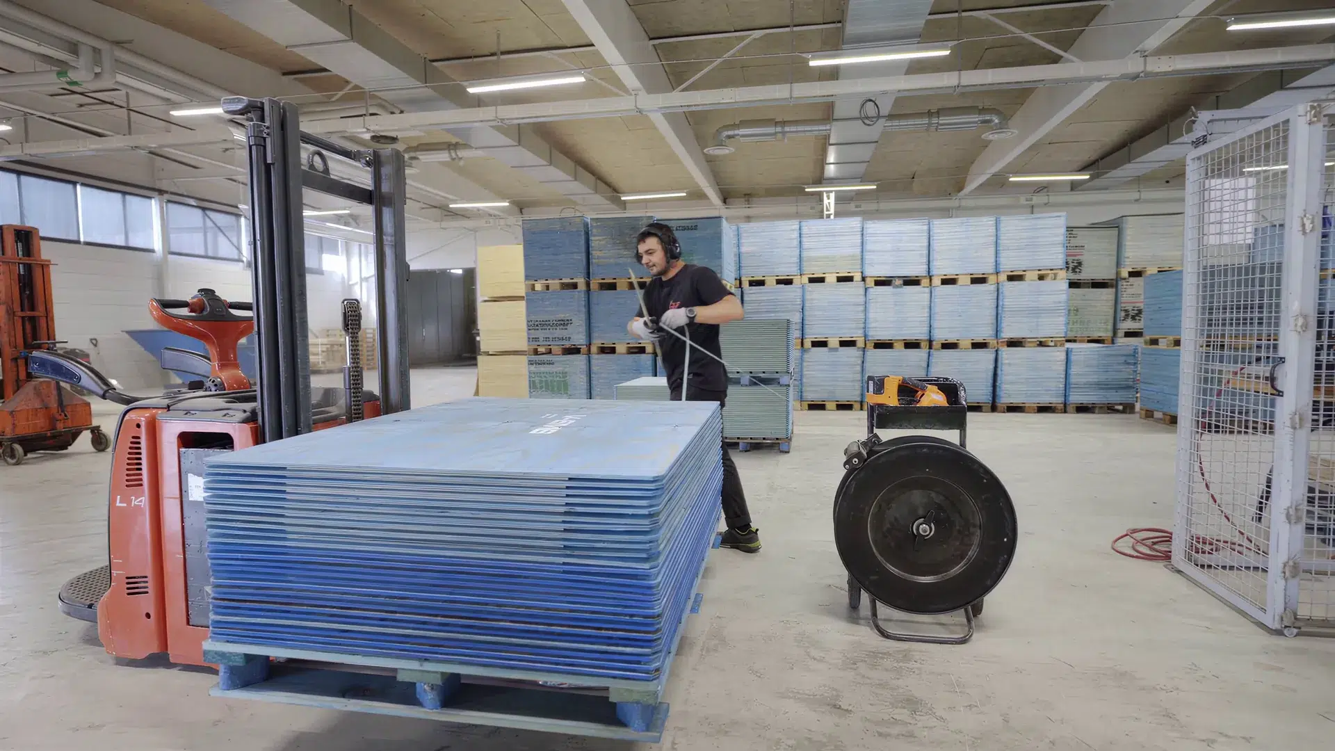 Painted plywood lids with white markings stacked on a pallet during packing.