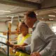 Deux personnes discutent près d’un garde-corps dans l’atelier de production GLF.