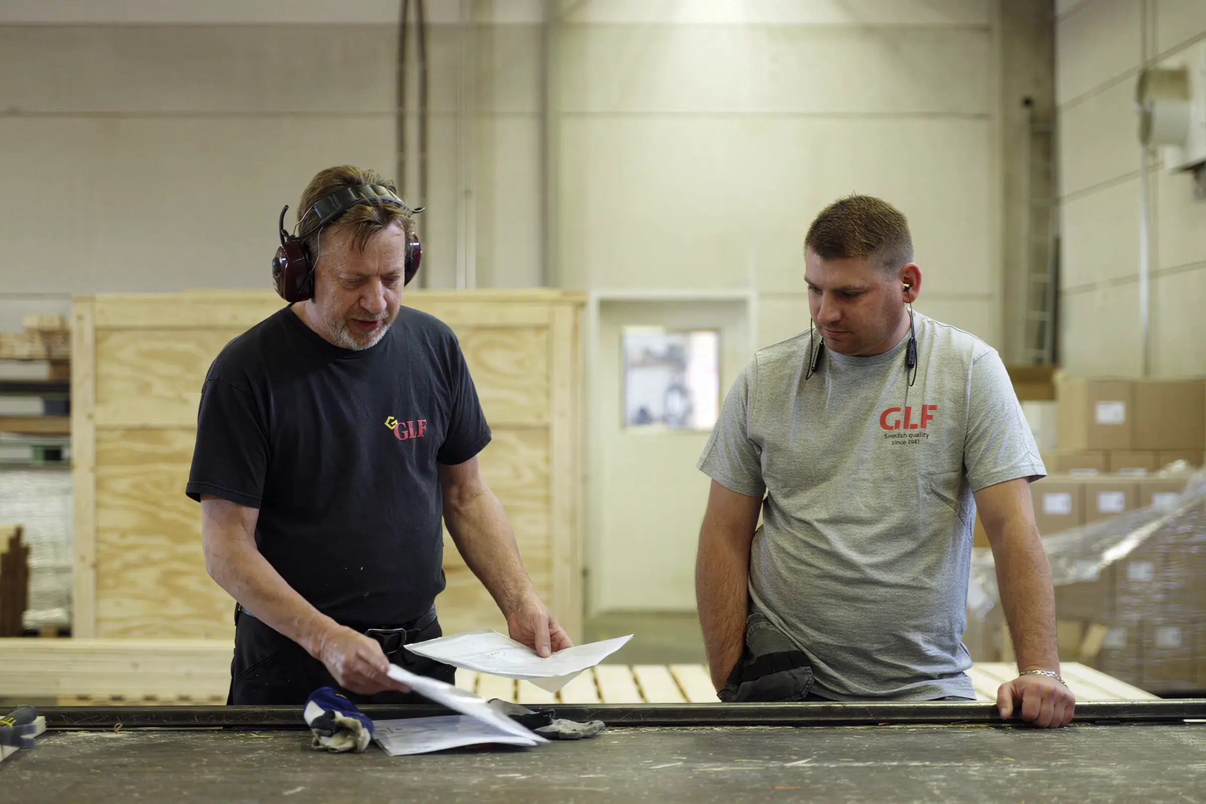 Colleagues work together on wooden packaging in GLF's production facility.